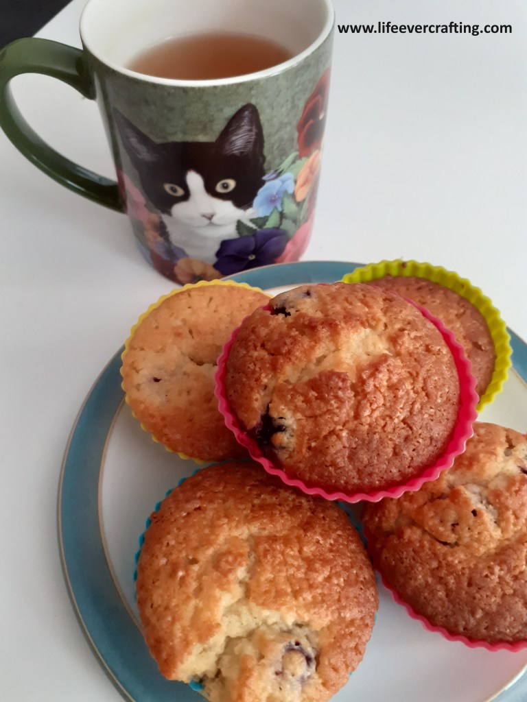 Image shows a plate of fairy cakes with a cup of tea.