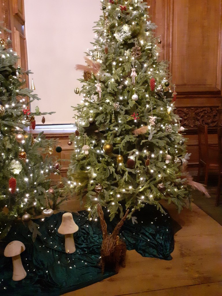 Image shows Christmas trees decorated with a woodland theme.