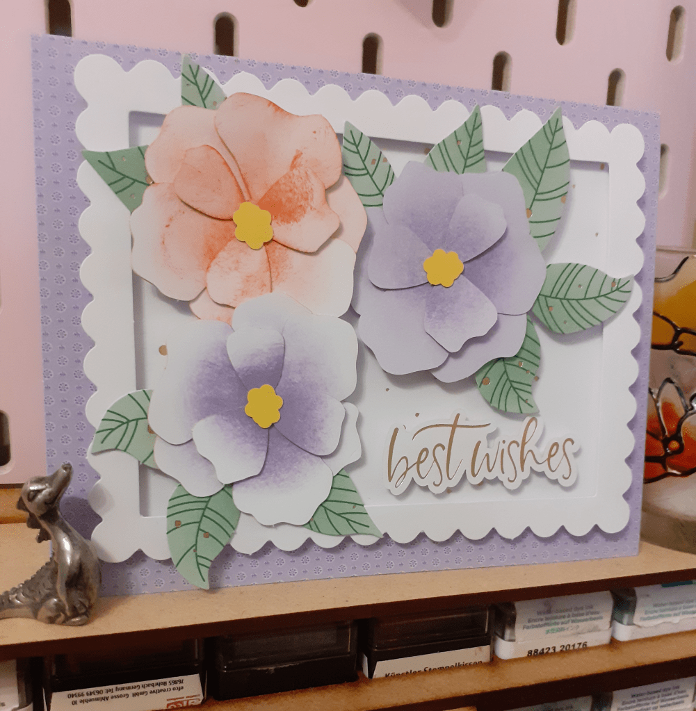 Image shows a card with three flowers and leaves 